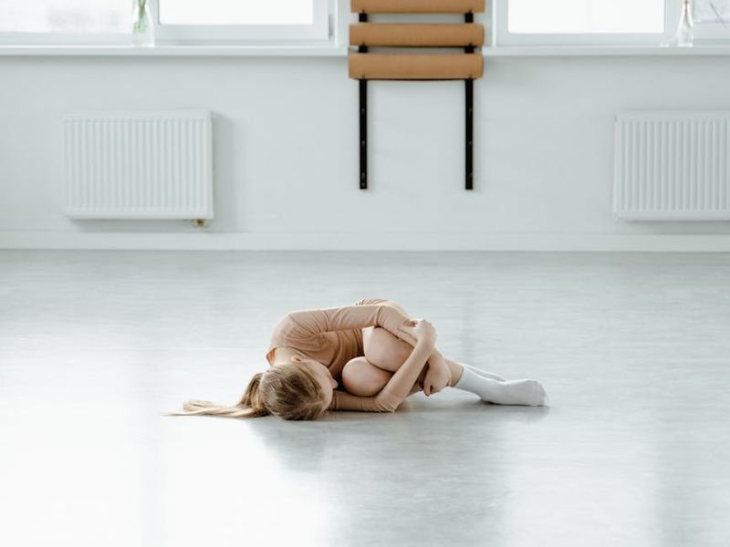 Minimalist yoga studio space with wooden floor and blue light
