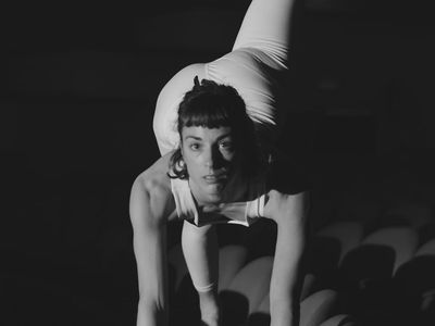 Silhouetted person performing a calm stretching exercise